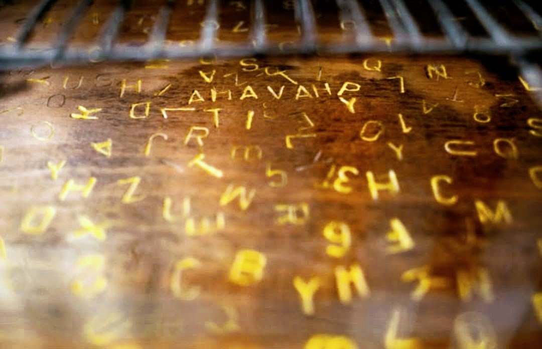 Letras e números gravados em uma superfície de madeira com uma grade no topo