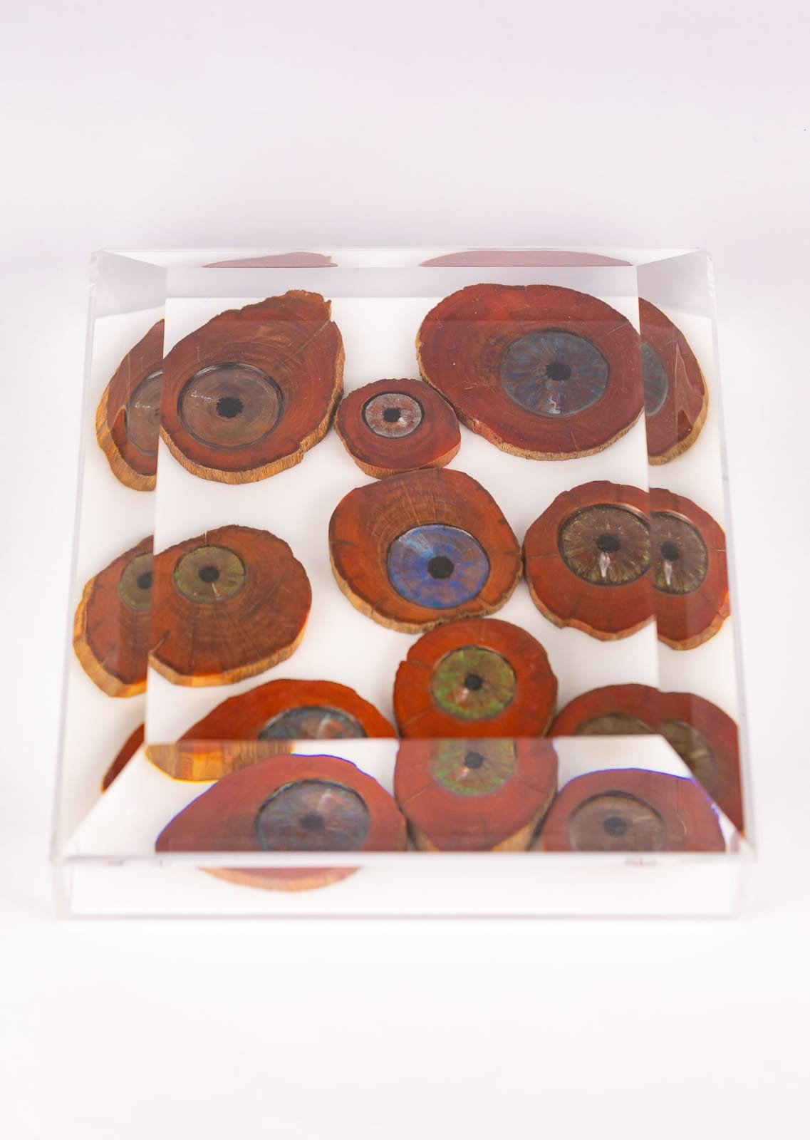 Várias esculturas em forma de olhos dentro de uma estrutura de vidro que servem como destaque